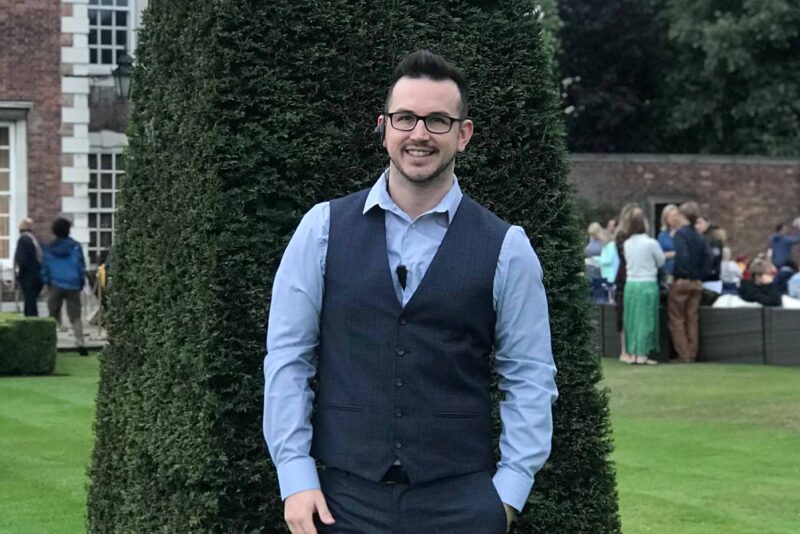A mad with a shirt and waist coat on standing in the gardens of Knowsley Hall