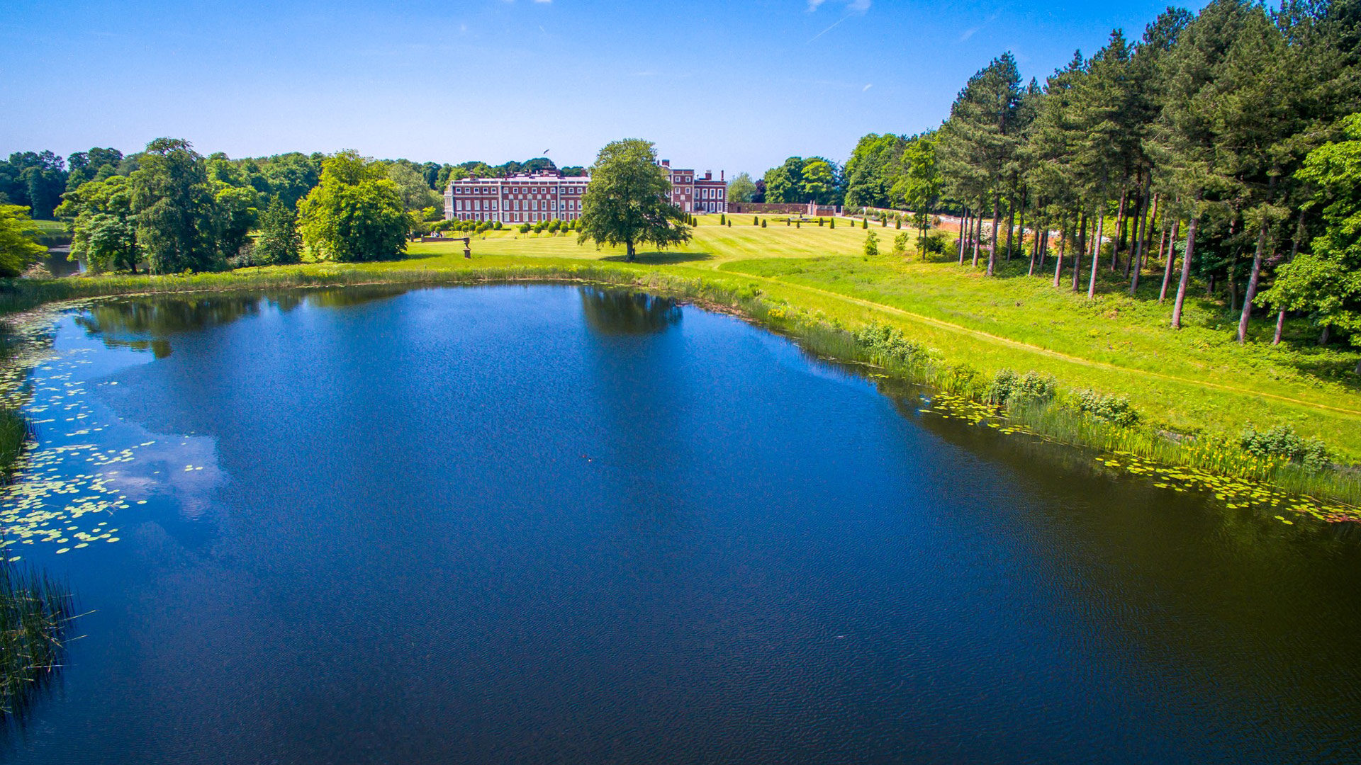 Drone photograph of Knowsley Hall from across the lake.