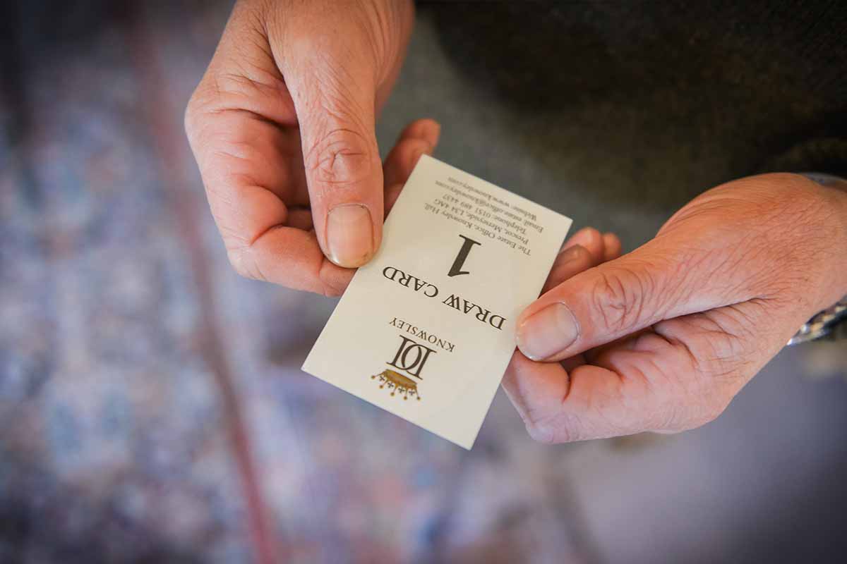 A pair of hands holding a small card