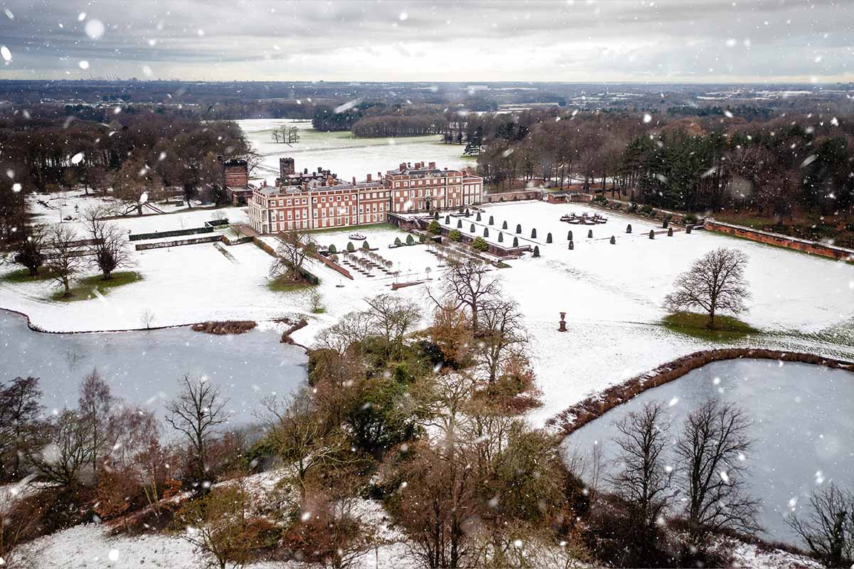 Aerial view of Knowsley Hall, a magnifcent stately home covered in snow on a winter wedding day
