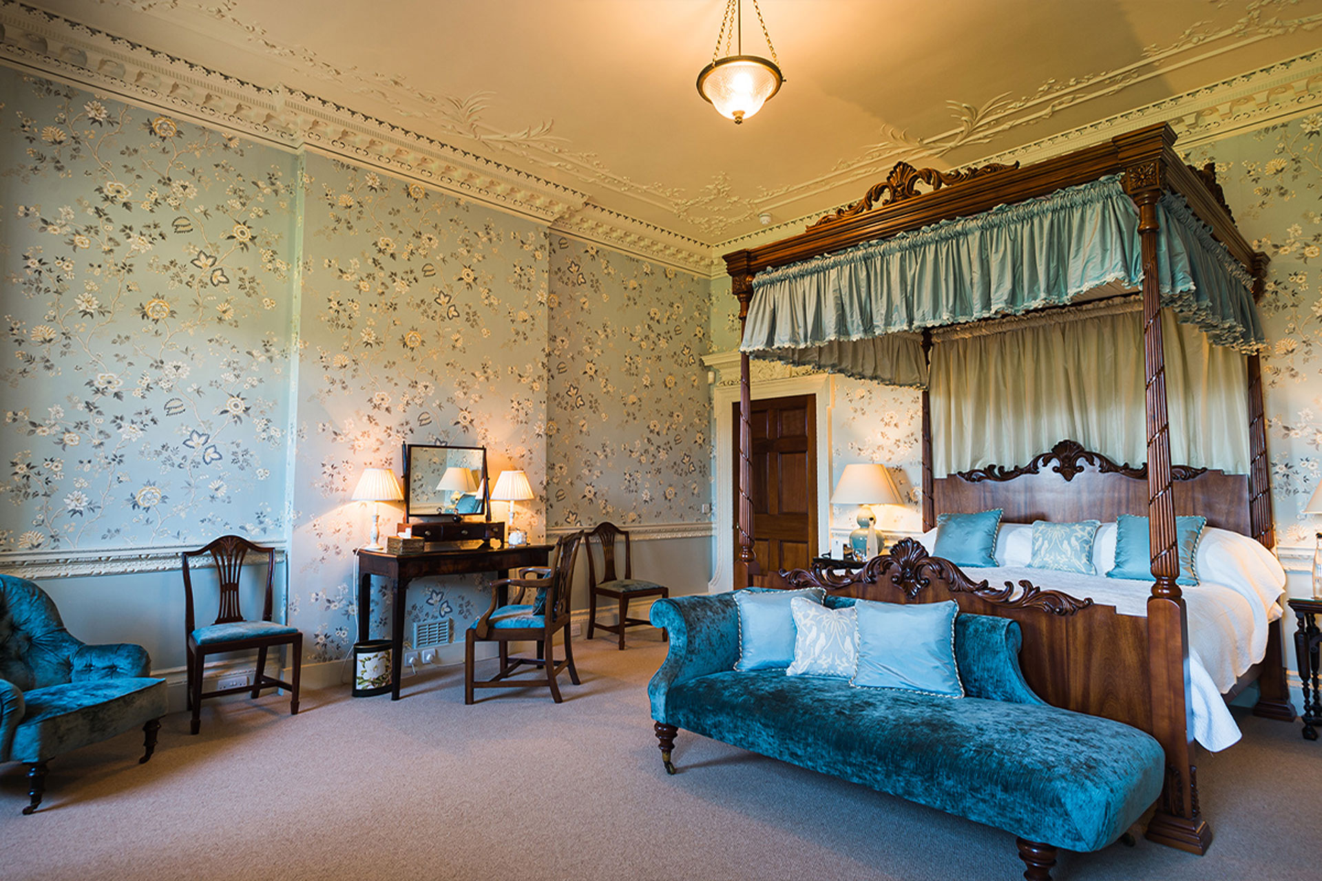 Luxurious honeymoon suite with deluxe four poster bed with blue tones