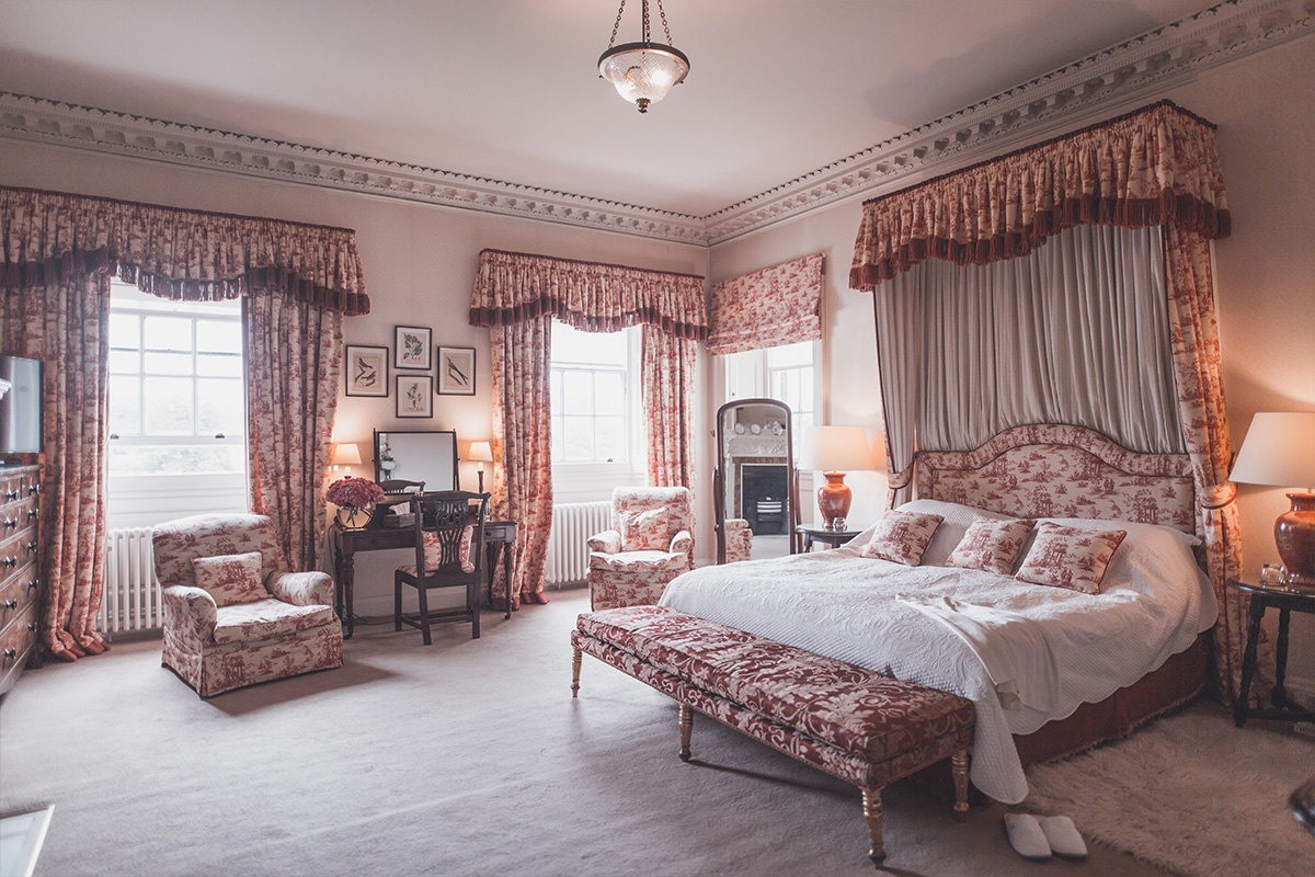 Luxury bedroom with King size bed and coronet in Knowsley Hall, a stately home in Merseyside